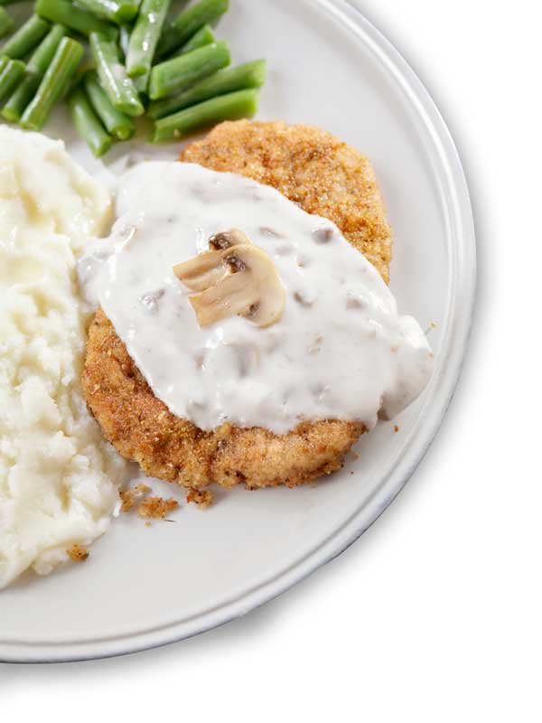 Denny's country fried steak on a plate with mashed potatoes and green beans