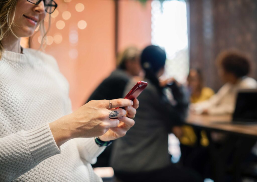 woman with smart phone in hands in a cafe