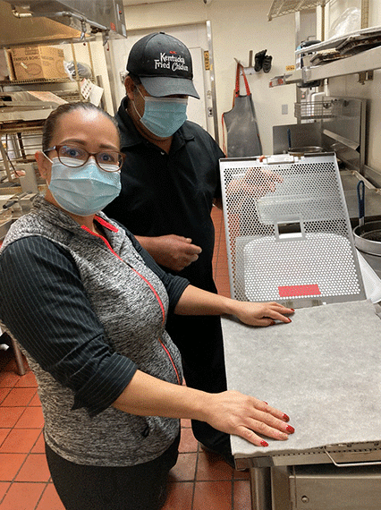 Restaurant Technologies employees Heidy and Curt demonstrating how grease lock reduces grease and flour build ups