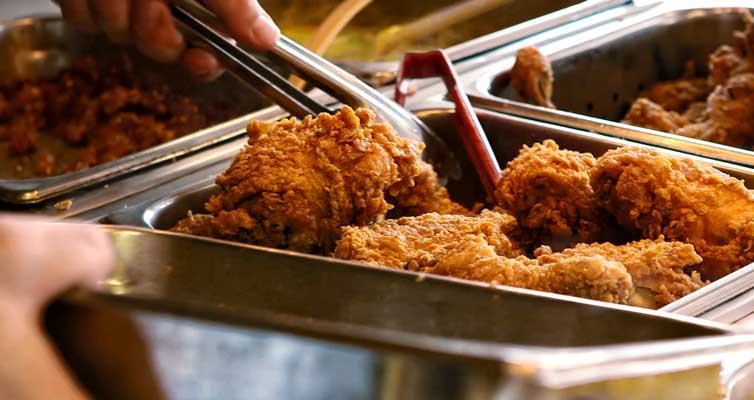Grabbing fried chicken from a buffet at KFC