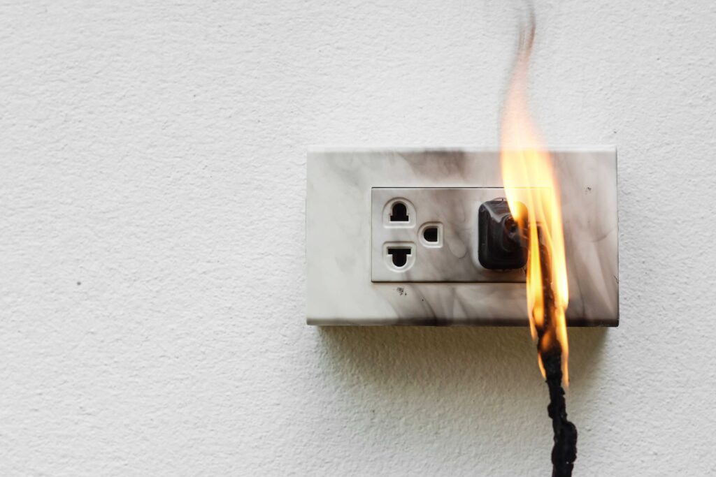 electrical outlet with plug on fire, fire safety